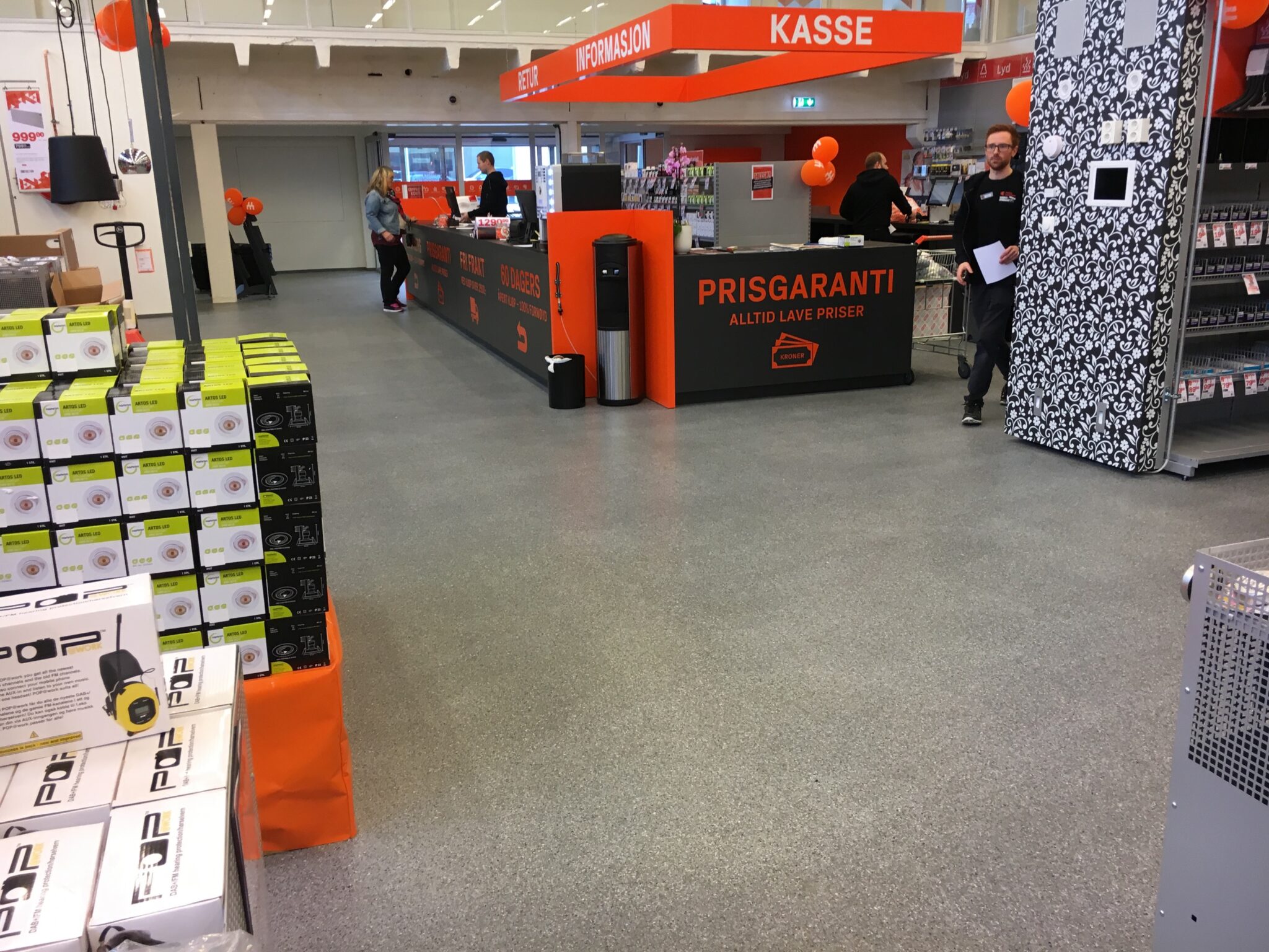 Elektros prekių parduotuvės kasų zona su pilka grindų danga